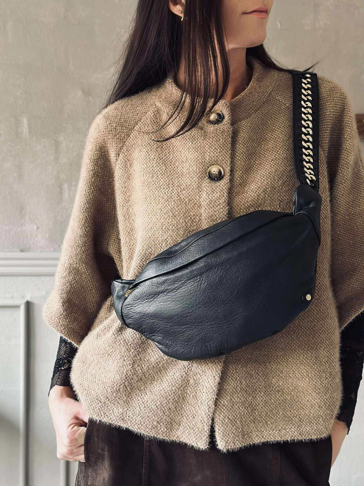 Bumbag met goudkleurige ketting op de schouderriem